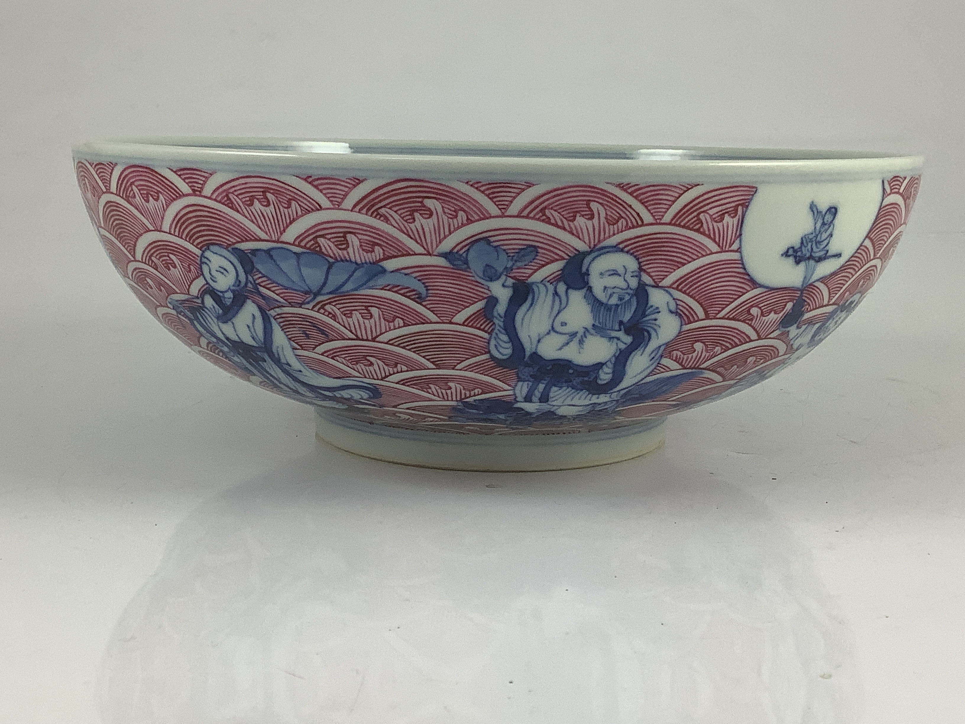 A Chinese underglaze blue and puce enamelled ’immortals’ bowl, 22cm diameter
